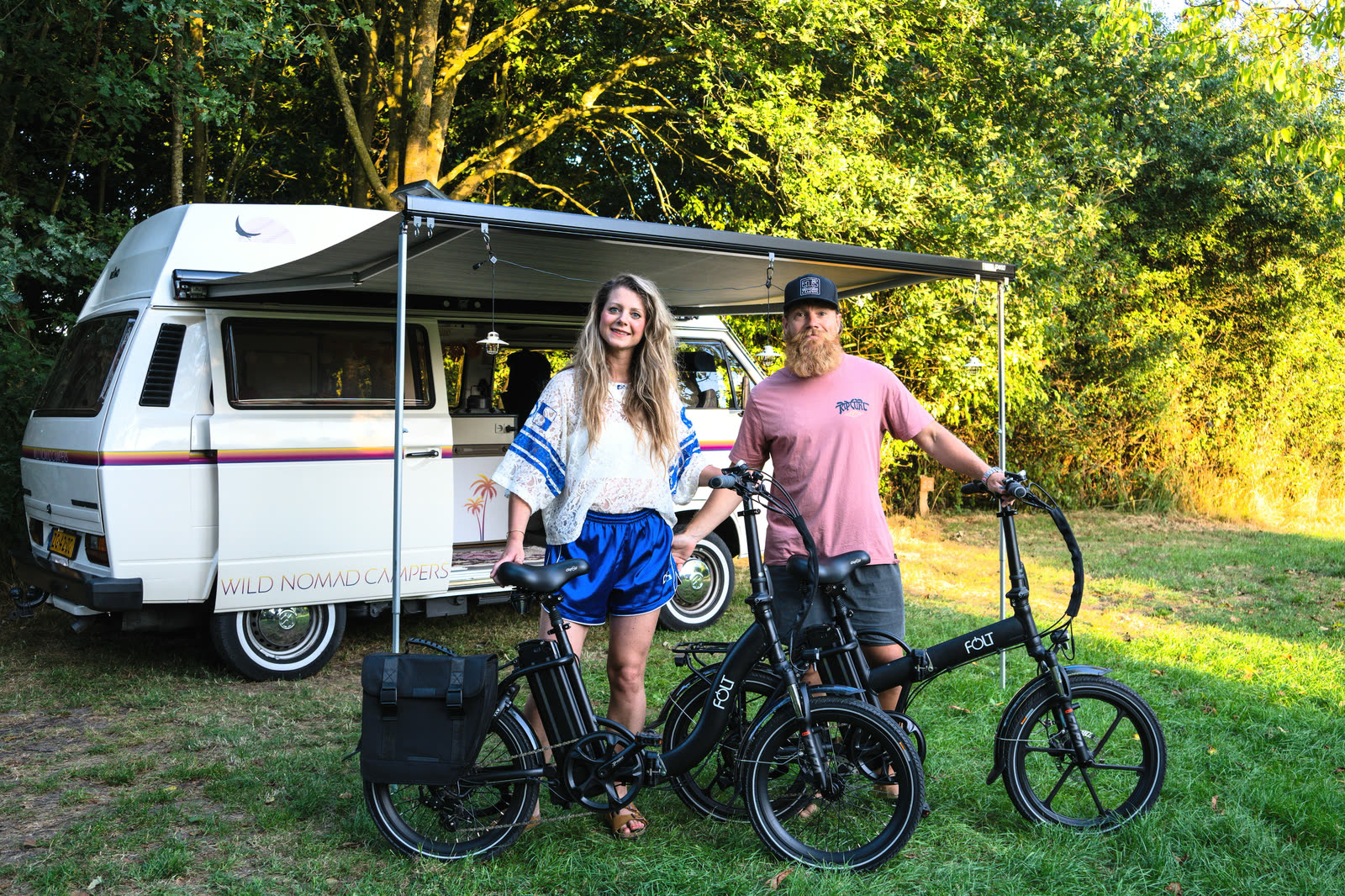 Stel met hun FOLT elektrische vouwfietsen bij hun camperbusje