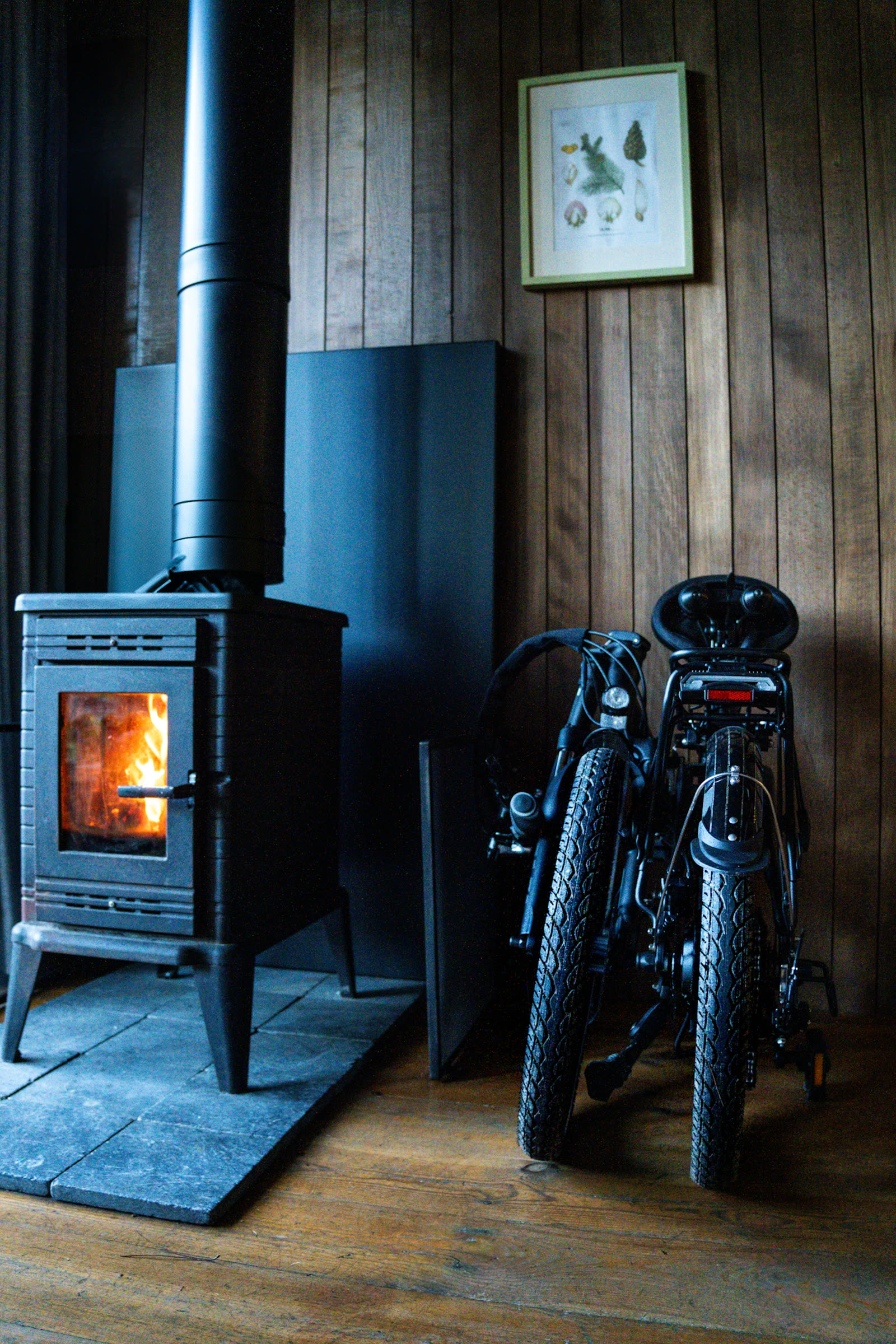 Opgevouwen FOLT vouwfiets naast een houtkachel